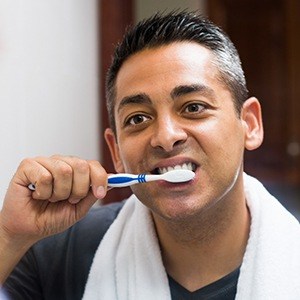 Man brushing his dental implants in Los Angeles 