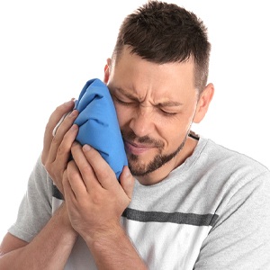 man holding a cold compress on his face to manage common symptoms