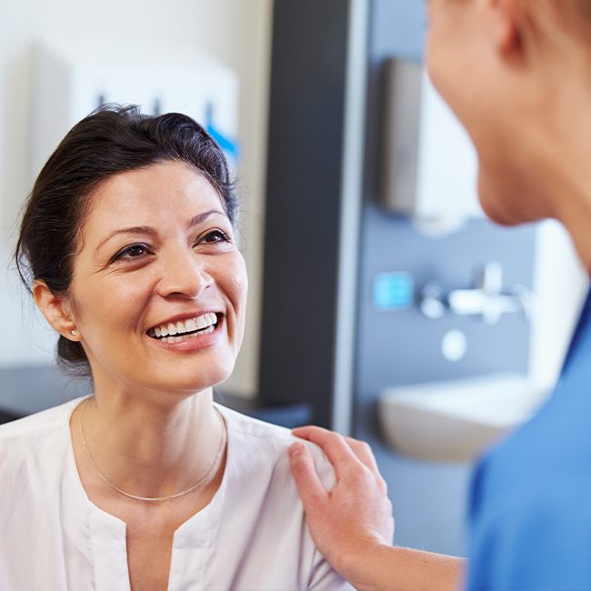 Woman smiling at dentist during preventive dentistry appointment