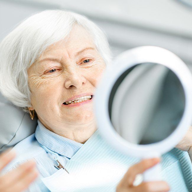 Woman looking at healthy smile after scaling and root planing periodontal therapy