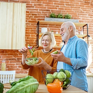 Older couple with dental implants in Los Angeles eating healthy