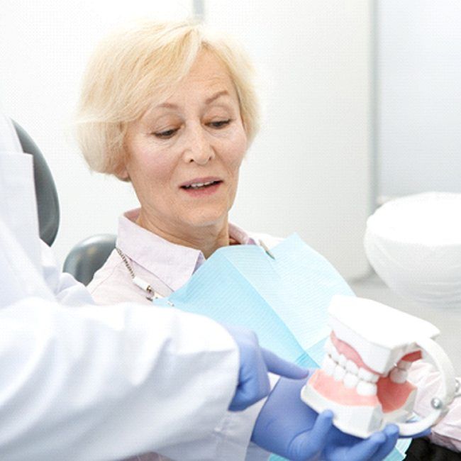 Woman at consultation being shown dentures