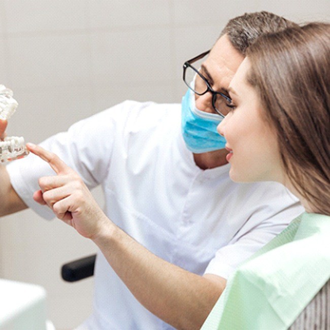 Woman learning how dental implants work in Los Angeles