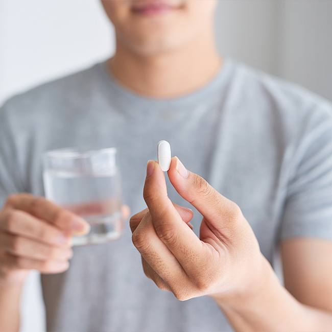 Patient holding oral conscious dental sedation pill