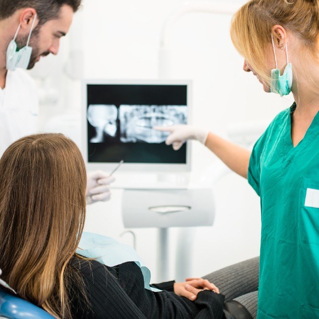 Dentist and patient looking at digital x-rays