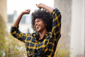 Woman with dental implants smiling outside