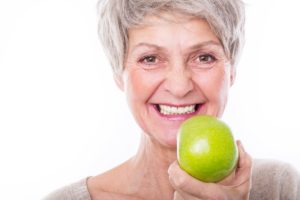 Woman with dentures holding an apple